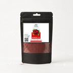 A black stand-up pouch of Hibiscus powder with a clear window showing the reddish-brown spice inside. The front label is white with a red and green hibiscus graphic and the brand name 'Hibiscus Organic'.